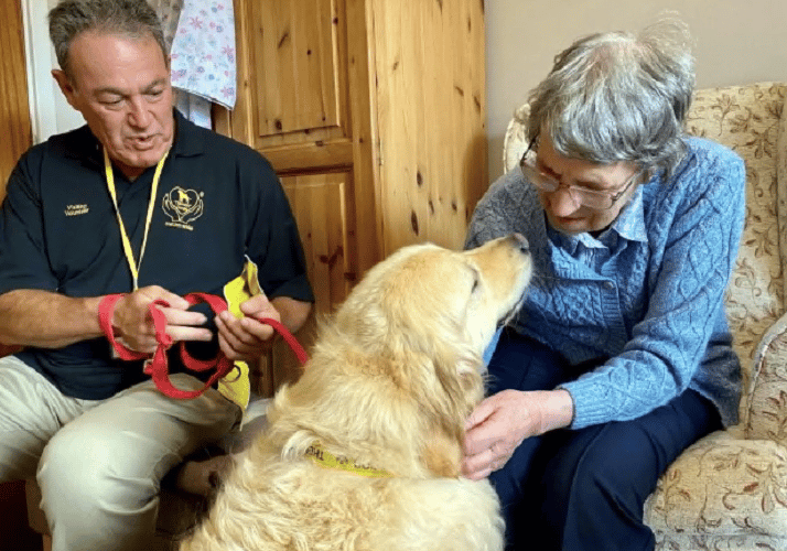 Bailey, the Golden Retriever, who volunteers from Therapy Dogs Nationwide, with his owner, Grant meeting residents