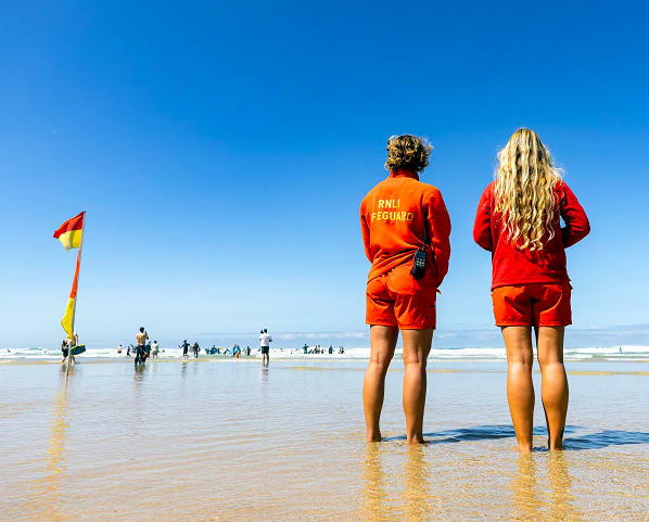 RNLI lifeguards Vittoria Farmer (from Autralia) and Theresa Morokutti (from Austria) monitoring the sea at Mawgan Porth beach, Newquay. Picture: RNLI/Nathan Williams