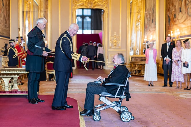 Dicky Evans being knighted by King Charles III.