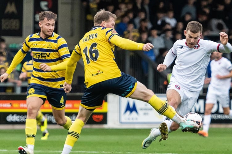 Truro striker Andrew 'Rocky' Neal looks to knock the ball past former City defender Ed Palmer. Picture: Colin Bradbury