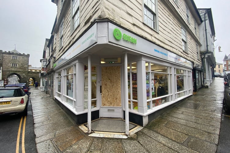 The glass panel on the Oxfam front door on Broad Street, Launceston, is currently boarded up but the shop remains open