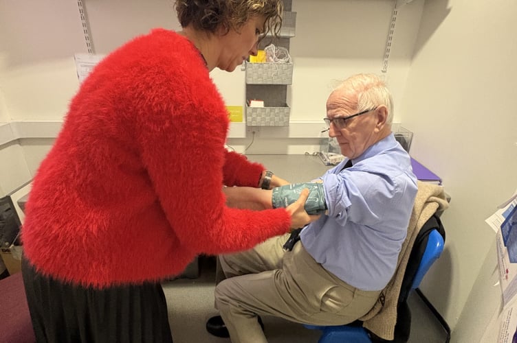 Pharmacist Judit Barta with member of the public having his blood pressure checked